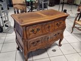 une petite commode dans une pièce où il y a beaucoup de meubles