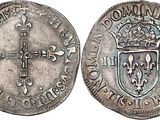 a silver coin with a cross on the front and a shield on the back