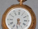 a gold pocket watch with roman numerals on it
