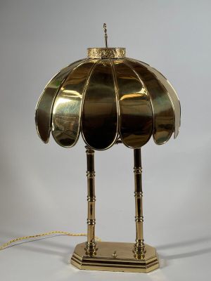 a brass table lamp with a brass shade on top of it