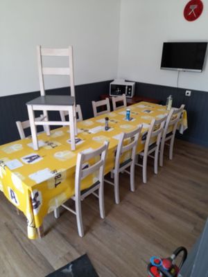 a table and chairs in a room with a clock on the wall