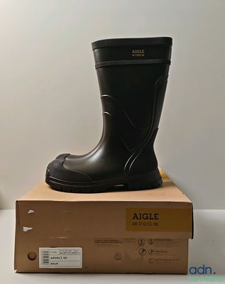a pair of black rain boots sitting on top of a box