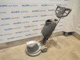 an image of a floor scruber in a room with a wall in the background
