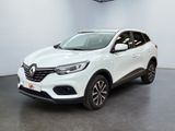 Une voiture blanche est garée dans une pièce équipée d'un ventilateur de plafond