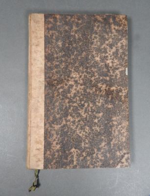 an old book sitting on top of a table next to a cup of coffee