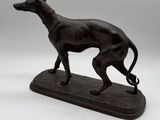 an image of a statue of a dog on a wooden base
