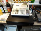 une calculatrice posée sur un comptoir, à côté de bouteilles d'alcool
