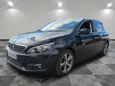 a black car is parked in a room with a checkered floor