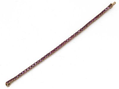 un gros plan d'un bracelet violet sur fond blanc