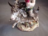 a figurine of a man riding a goat