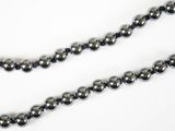 un gros plan d'un collier de perles noires sur fond blanc