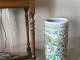 une table avec un vase et une lampe à côté