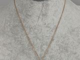 a gold necklace with a cross pendant on a mannequin mannequin