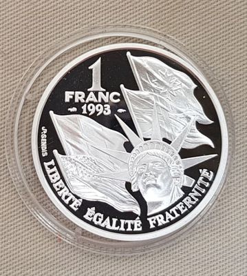 un gros plan d'une pièce d'argent sur laquelle figure un drapeau
