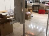 a mannequin on a stand in the middle of a room
