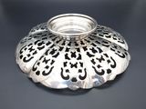 a silver candle holder on a table with a black background