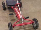 a red and black go kart sitting on the floor