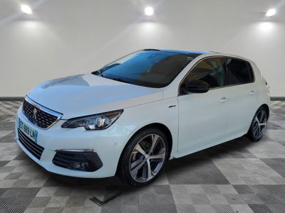 une voiture blanche est garée dans une pièce au sol à carreaux