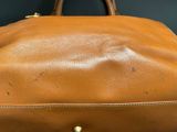 an image of a brown leather bag sitting on top of a table