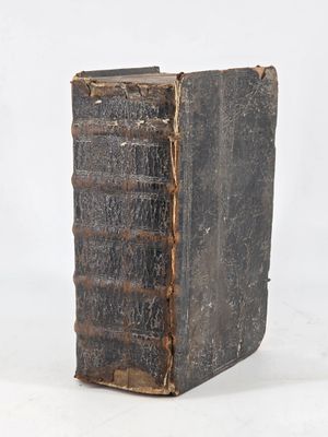 an old book sitting on top of a table next to a white wall