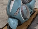 un scooter bleu posé sur une boîte