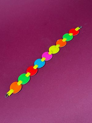 a colorful bracelet made out of plastic beads on a purple surface