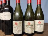 several bottles of wine are lined up on a wooden table