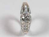a close up of a diamond ring on a white surface