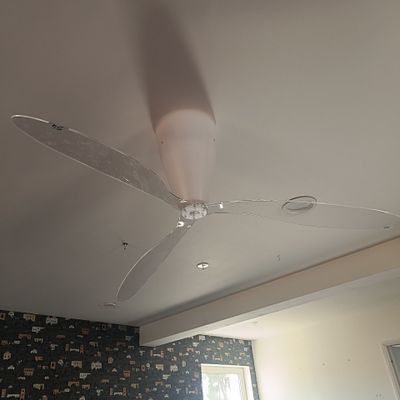 un ventilateur de plafond dans une pièce dont l'un des murs est tapissé