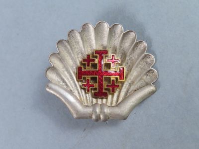 a silver shell with a red cross on it