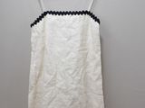 a white dress hanging on a hanger against a white wall