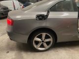 une voiture argentée dont la portière est ouverte sur un parking