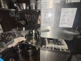 a man that is standing in a kitchen with pots and pans on the stove