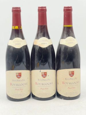 trois bouteilles de vin rouge sont alignées sur une surface blanche