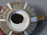 a person holding a vase with a hole in it