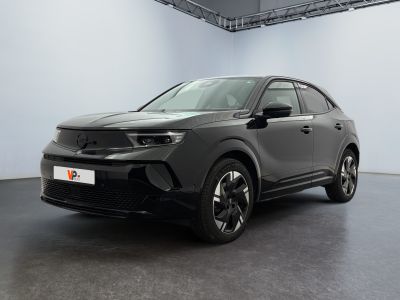 un SUV noir garé dans une grande pièce aux murs blancs