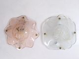 deux morceaux de verre posés sur une surface blanche : l'un est rose et l'autre est transparent