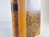 an old book with a gold cover and a black binding
