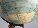 a large globe on a wooden stand with a map on it