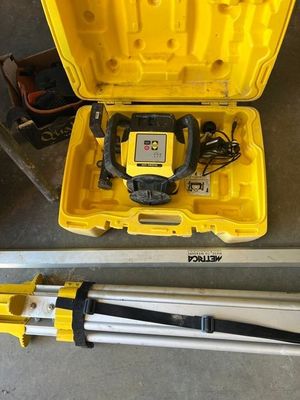 an image of a yellow tool box with a tripod and a laser