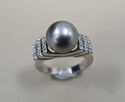 une image d'une bague ornée d'une perle et de diamants