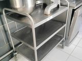 a metal shelf with pots and pans on it in a kitchen