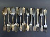 six cuillères et six fourchettes disposées en rangée sur une table