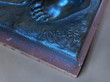 a bronze statue of a hand holding an apple