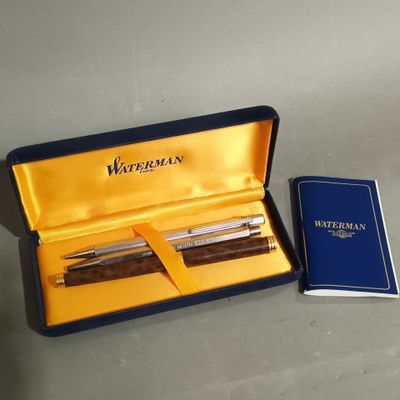 two pens and a notebook in a box on a table
