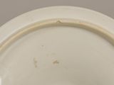 a white bowl with a brown rim on a table