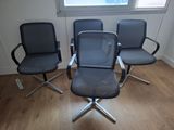 three office chairs sitting in front of a window on a hard wood floor