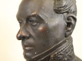 a bronze bust of a man with a collared shirt on