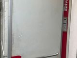 un réfrigérateur blanc muni d'une poignée rouge dans une pièce