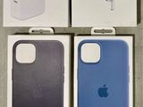 trois boîtes contenant des coques pour iPhone et des écouteurs, posées sur une table
